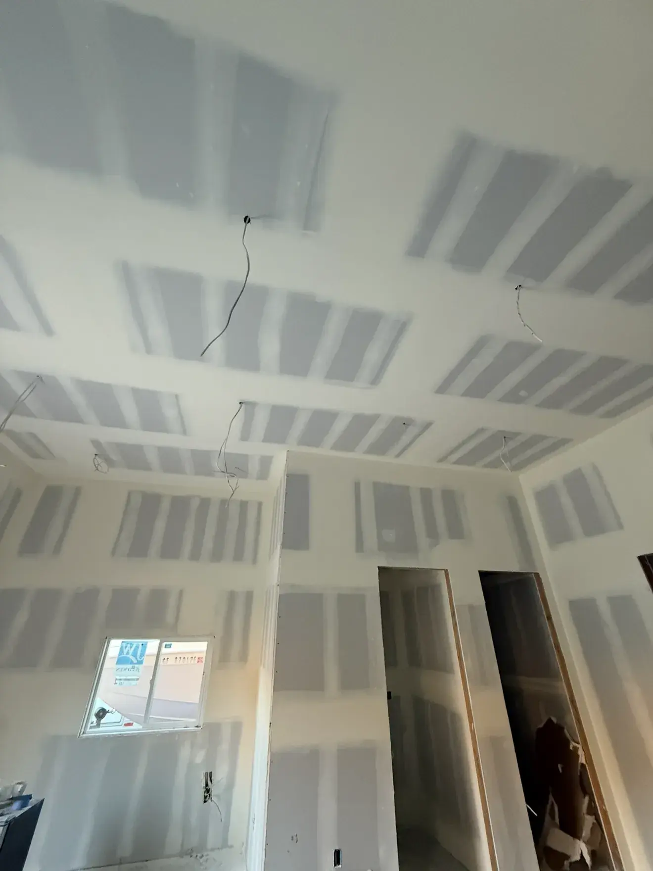 Bedroom with ceiling and walls fully taped, sanded and ready for primer