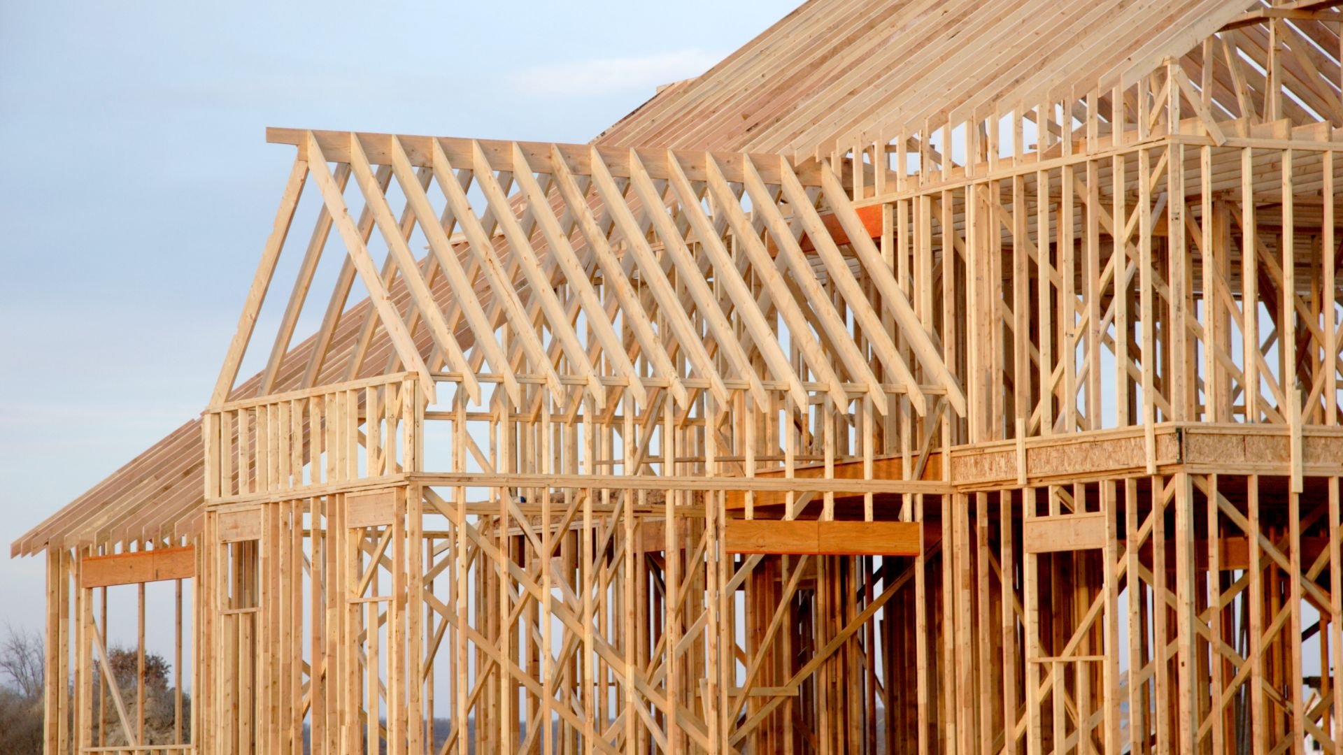 Wooden house frame under construction with exposed timber framing